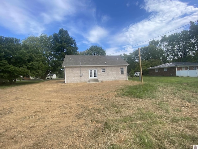 rear view of house featuring entry steps and a yard