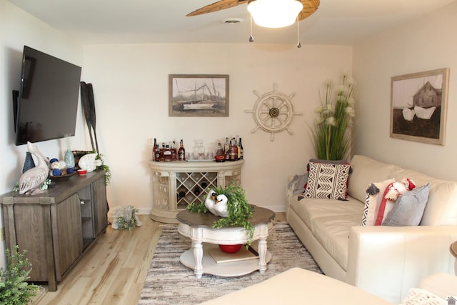 living room featuring light wood-style flooring and a ceiling fan