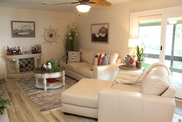 living area with a ceiling fan and wood finished floors