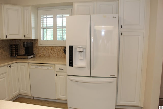 kitchen with tasteful backsplash, light hardwood / wood-style flooring, white appliances, and white cabinetry