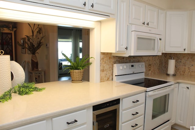 kitchen featuring decorative backsplash, white appliances, wine cooler, and white cabinetry