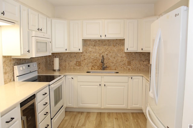 kitchen featuring beverage cooler, white appliances, a sink, light countertops, and decorative backsplash