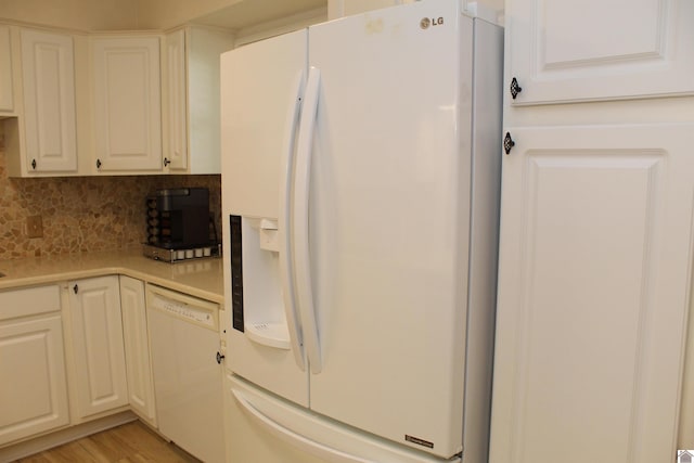 kitchen with white appliances, decorative backsplash, light hardwood / wood-style floors, and white cabinetry