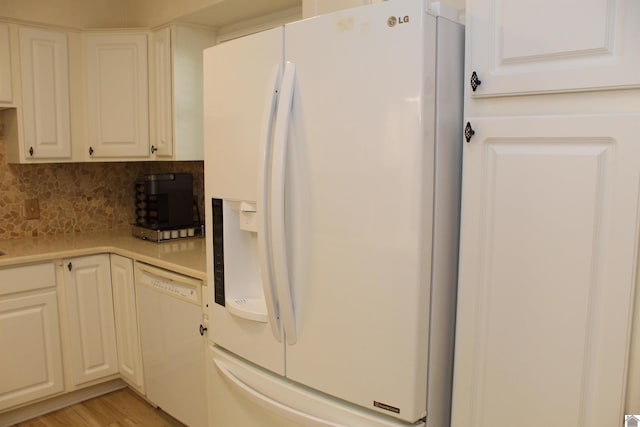 kitchen featuring white appliances, decorative backsplash, light wood-style flooring, light countertops, and white cabinetry