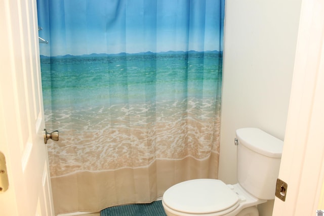 bathroom with curtained shower and toilet