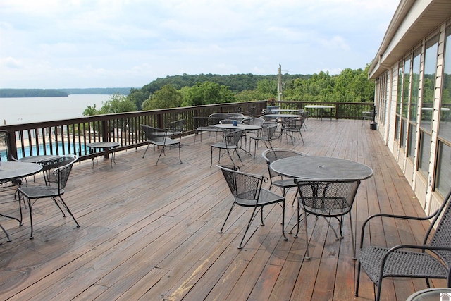 deck featuring a water view and a fenced in pool