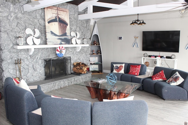 living area with a stone fireplace and wood finished floors