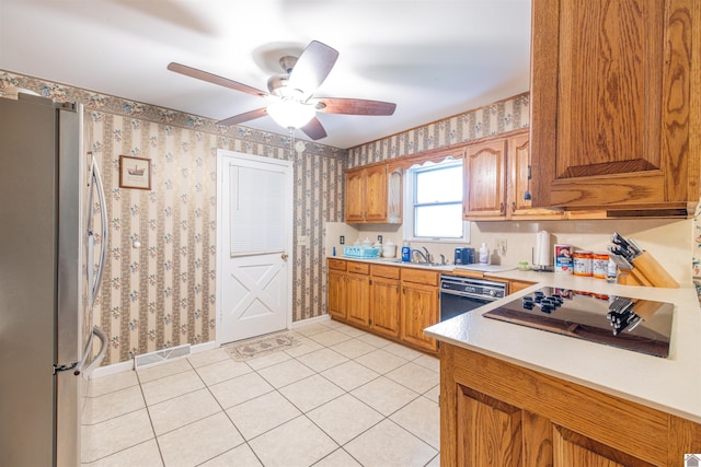 kitchen featuring sink, light tile patterned flooring, black appliances, and ceiling fan