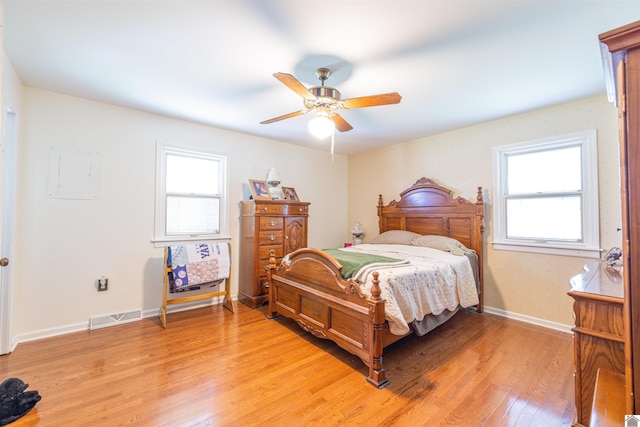 bedroom featuring hardwood / wood-style flooring, multiple windows, and ceiling fan