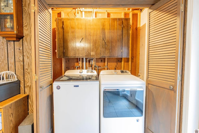 washroom featuring wood walls and washing machine and clothes dryer