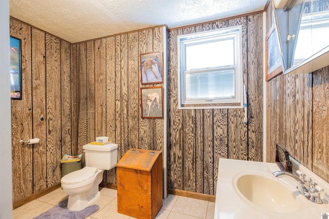 bathroom featuring toilet, a wealth of natural light, tile patterned flooring, and wooden walls