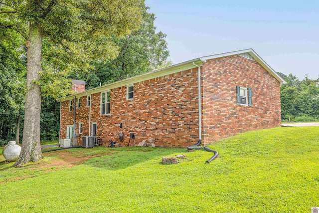 view of property exterior with central AC and a lawn