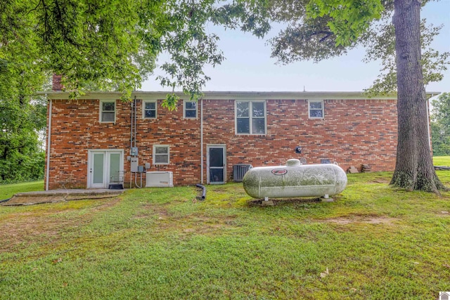 rear view of property featuring central AC unit, french doors, and a lawn