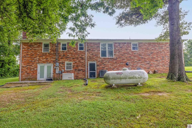 back of property with cooling unit, a yard, and french doors