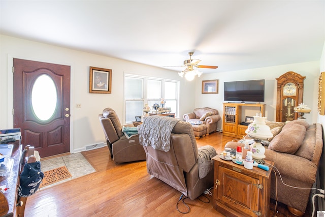 living room with light hardwood / wood-style flooring and ceiling fan