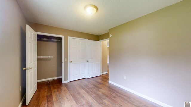 unfurnished bedroom with hardwood / wood-style flooring, a closet, and a textured ceiling