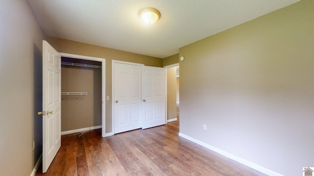 unfurnished bedroom with hardwood / wood-style flooring, a closet, and a textured ceiling