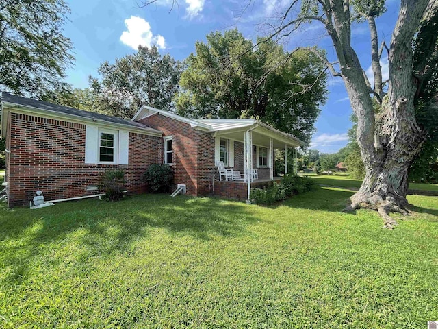 view of front of property with a porch, crawl space, brick siding, and a front lawn