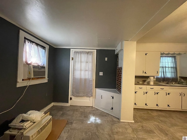 interior space featuring light tile patterned flooring, a wealth of natural light, and white cabinets