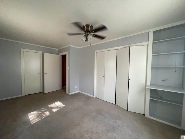 unfurnished bedroom featuring carpet flooring, crown molding, baseboards, and ceiling fan