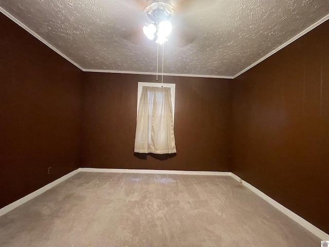 spare room featuring ornamental molding, carpet flooring, a textured ceiling, and baseboards