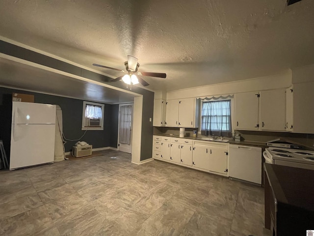 kitchen with dark countertops, white appliances, white cabinetry, and a textured ceiling