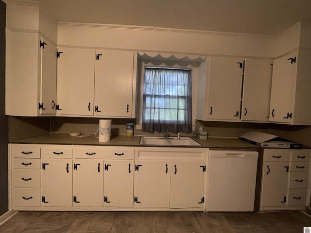 kitchen featuring dark countertops, white dishwasher, a sink, and white cabinets