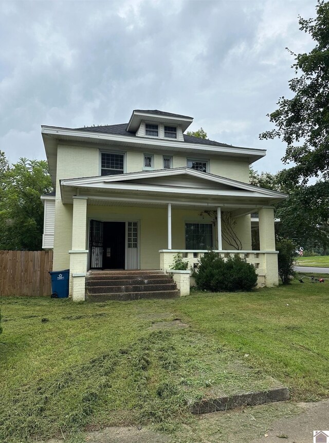 view of front of property with covered porch and a front yard