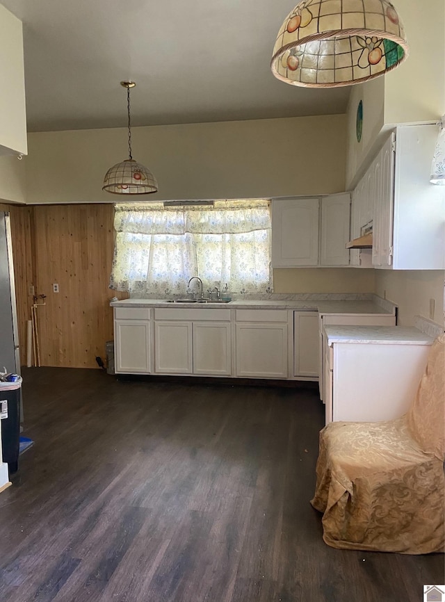 kitchen featuring dark wood-type flooring, pendant lighting, white cabinets, and sink