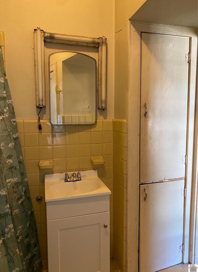 bathroom with vanity and tile walls