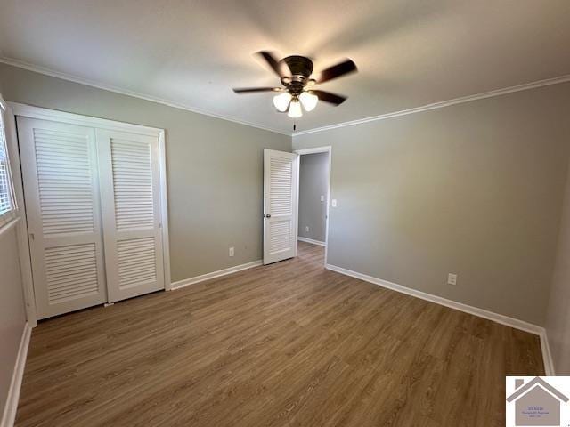 unfurnished bedroom featuring wood-type flooring, crown molding, ceiling fan, and a closet