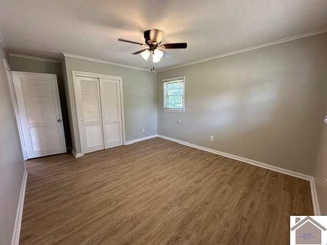 unfurnished bedroom featuring crown molding, ceiling fan, wood-type flooring, and a closet