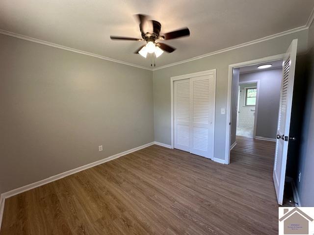 unfurnished bedroom featuring ceiling fan, ornamental molding, dark hardwood / wood-style floors, and a closet