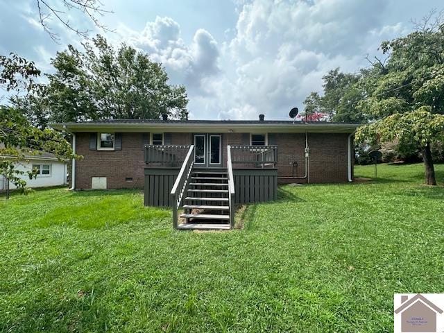 rear view of house featuring a deck and a lawn