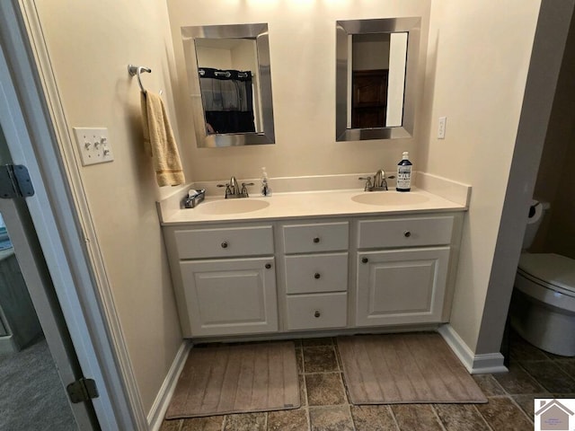 bathroom featuring double vanity, toilet, and tile patterned floors