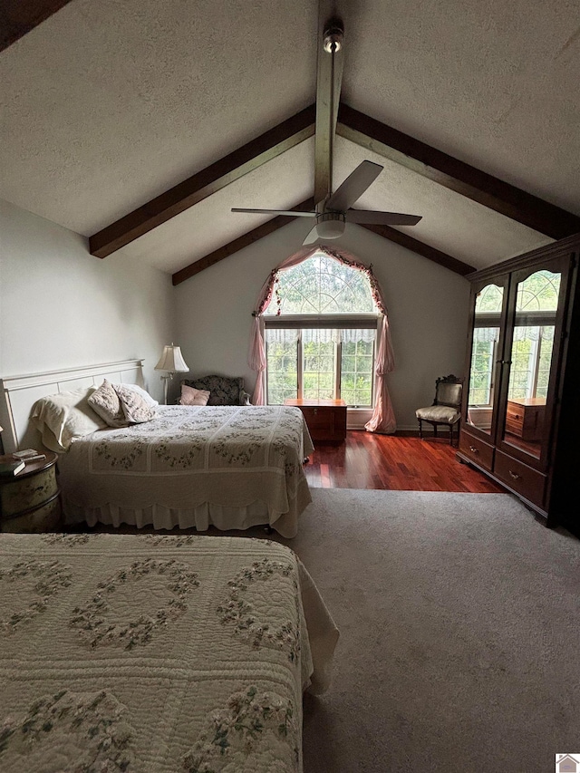 bedroom featuring wood-type flooring, vaulted ceiling with beams, multiple windows, and ceiling fan