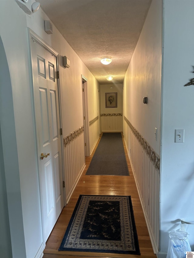 corridor featuring dark hardwood / wood-style floors and a textured ceiling