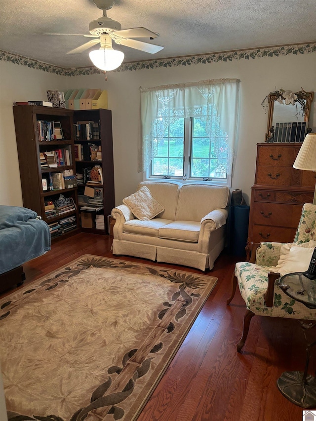 living room featuring a textured ceiling, ceiling fan, and dark hardwood / wood-style floors