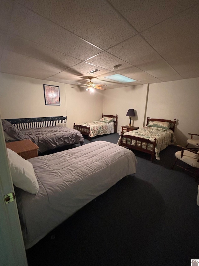 bedroom with ceiling fan and a paneled ceiling