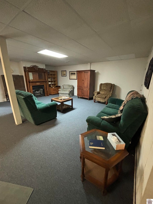 living room featuring a drop ceiling and carpet flooring