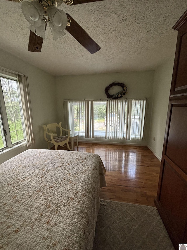 unfurnished bedroom featuring hardwood / wood-style flooring, ceiling fan, and a textured ceiling