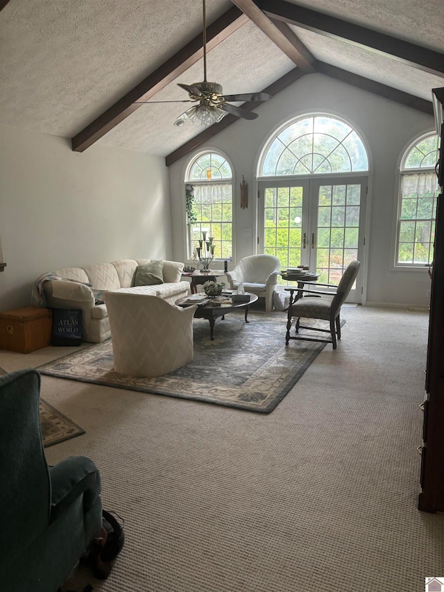 living room featuring a textured ceiling, lofted ceiling with beams, carpet floors, and ceiling fan