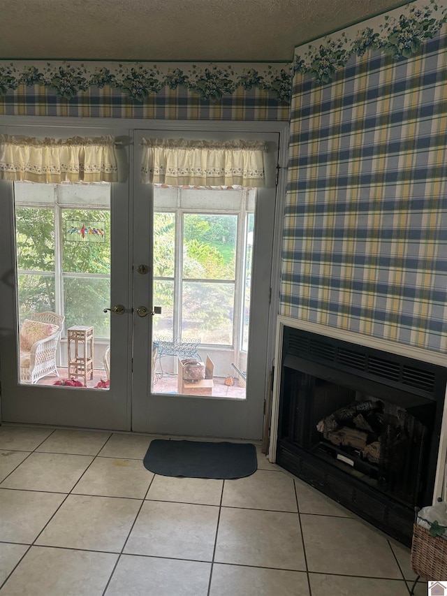 doorway featuring light tile patterned flooring, a textured ceiling, and french doors