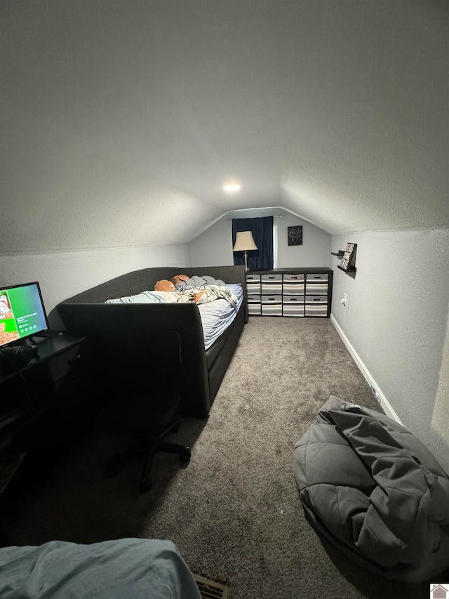 bedroom with a textured ceiling, carpet floors, and vaulted ceiling