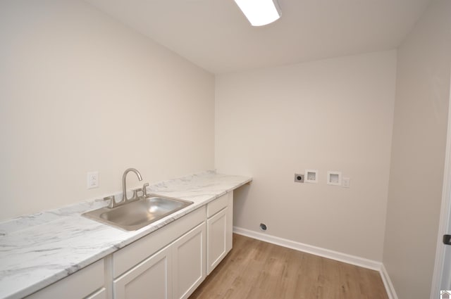 washroom with sink, cabinets, hookup for a washing machine, hookup for an electric dryer, and light wood-type flooring