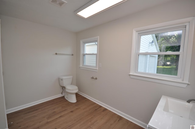 bathroom with hardwood / wood-style flooring, vanity, and toilet