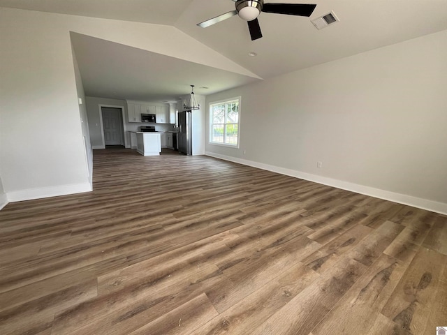 unfurnished living room with lofted ceiling, ceiling fan with notable chandelier, and wood-type flooring