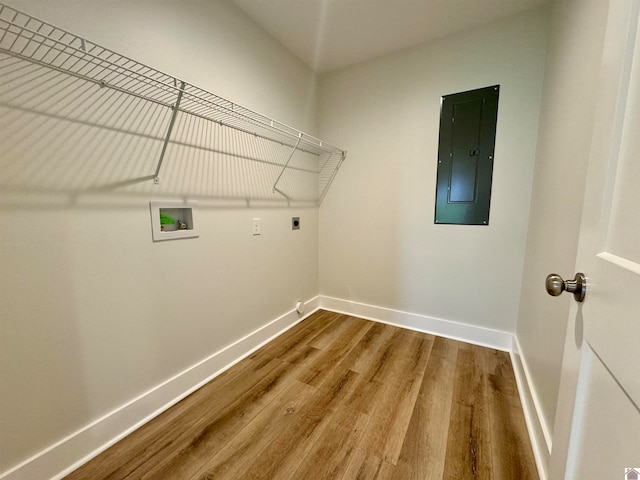 washroom featuring hardwood / wood-style floors, electric panel, hookup for a washing machine, and hookup for an electric dryer