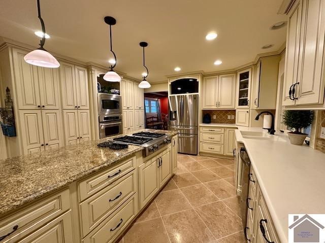 kitchen with tasteful backsplash, hanging light fixtures, appliances with stainless steel finishes, and light tile patterned floors