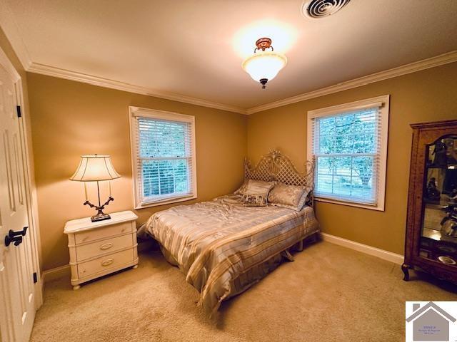 bedroom featuring visible vents, crown molding, light carpet, and baseboards